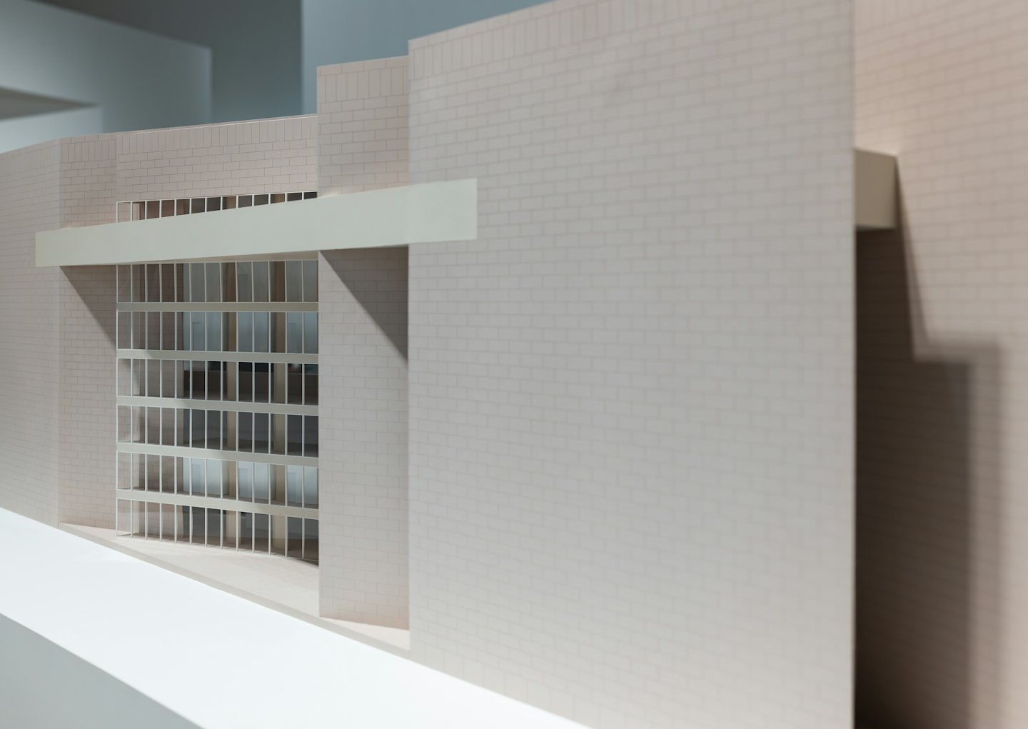 Maqueta arquitectónica moderna de un edificio de ladrillo con grandes ventanales.